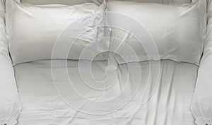 Top view of white bedding sheets and pillow in bed room, Messy bed concept