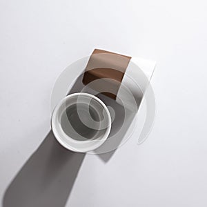 Top view of white and brown ceramic cups on a white surface