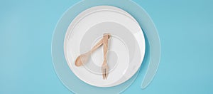 Top view white ceramic plate with knife, spoon and fork on blue background. Intermittent fasting, Ketogenic dieting, weight loss,