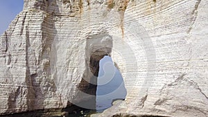 Top view of white cliff with arch. Action. Arched passage in white cliff - beautiful miracle of nature, created in