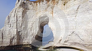 Top view of white cliff with arch. Action. Arched passage in white cliff - beautiful miracle of nature, created in