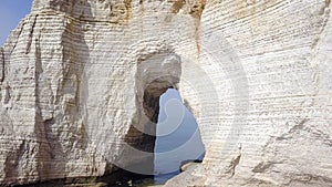 Top view of white cliff with arch. Action. Arched passage in white cliff - beautiful miracle of nature, created in