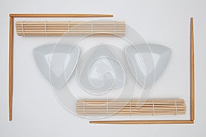 Top View Of White Empty Sushi Plates With Bamboo Chopsticks and Mats