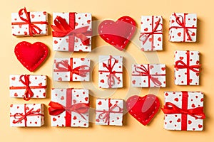 Top view of white gift boxes and red textile hearts on colorful background. Valentine`s Day concept