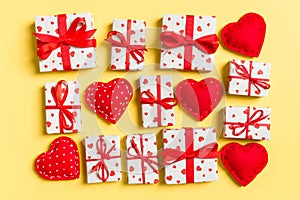 Top view of white gift boxes and red textile hearts on colorful background. Valentine`s Day concept