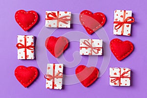 Top view of white gift boxes and red textile hearts on colorful background. Valentine`s Day concept