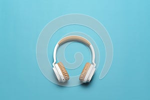 Top view of white headphones on blue background with copy space