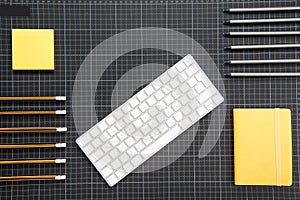 Top view of white keyboard and organized office supplies