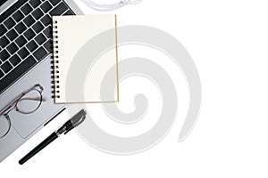 Top view white minimal office desk table with laptop, notebook, eyeglass and pen on white background