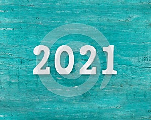 Top view of a white number 2021 as a symbol of the coming New Year. Happy New Year Holiday concept on a turquoise rustic wooden