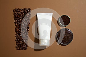 Top view of white plastic tube unlabeled displayed with coffee beans and petri dish filled with coffee grounds on brown background