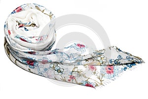 Top view of a white rolled up scarf with floral design on a white surface