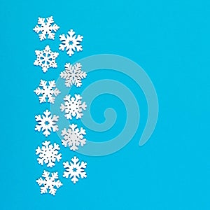 Top view of white snowflakes on colorful background. Winter weather concept with copy space. Merry Christmas concept