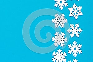 Top view of white snowflakes on colorful background. Winter weather concept with copy space. Merry Christmas concept