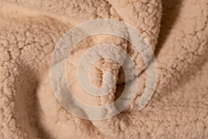 Top view of white soft sheepskin textile plaid. Warm cozy texture background