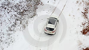 Top view of a white SUV driving on a snowy mountain road. Konorchek Canyon. Traveling by car in Kyrgyzstan.