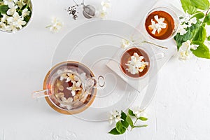 Top view of a white textured background with a teapot and two glass cups with fragrant healthy jasmine tea. soothing drink,