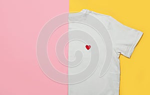 Top view of white woman t-shirt on pink and yellow background. Fashion clothes set. Flat lay. Place for text. 90`s style