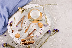 Top view of a white wooden podium with an empty coffee cup, cinnamon sticks, anise stars, flowers. blank design layout