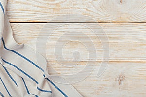 Top view on a white wooden table with a linen kitchen towel or textile napkin. a tablecloth on a light wood countertop