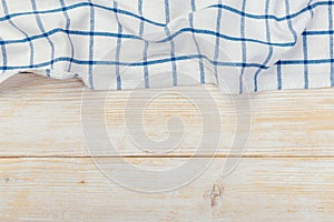 Top view on a white wooden table with a linen kitchen towel or textile napkin. a tablecloth on a light wood countertop