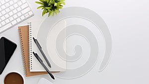 Top view white wooden workspace office desk with computer and office supplies. Flat lay work table with blank notebook, keyboard,