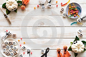 Top view of white and yellow ghost pumpkins with bat spider on white wooden background. photo