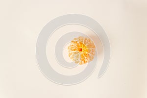 Top view of whole pelled tangerine citrus orange fruit on a white background. Fasting day with healthy fruitarian snack.