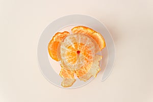 Top view of whole ripe peeled mandarin fruit with orange peels on a white background. Raw food diet and fruitarian.