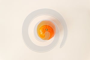 Top view of whole unpelled orange mandarin on a white background. Raw food diet and fruitarian concept. Space for text