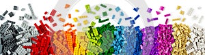 Top view of wide pile various colorful rainbow colored stackable plastic toy bricks isolated white panorama background.. childhood