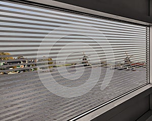 Top view through window blinds of the authentic town and windmills river landscape