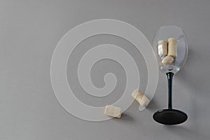 Top view of a wine glass goblet with wine corks on a gray background with place for text