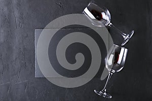 Top view of wineglasses, slate place mat on the black table.Empty space for text