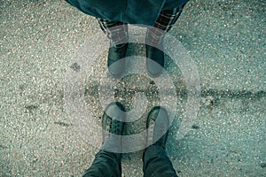 Top view of winter footwear from above, couple facing each other, man and woman standing on the street