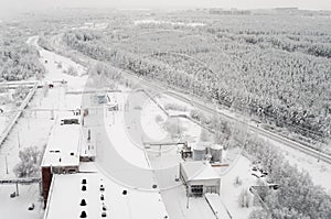 Top view at wintry rail road in evergreen forest with snow-capped trees. Winter season in Russia