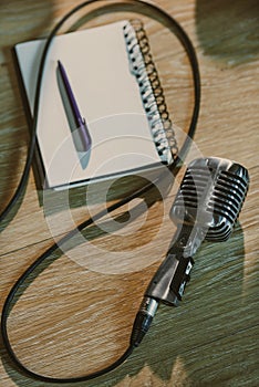 top view of wired retro microphone lying on wooden table