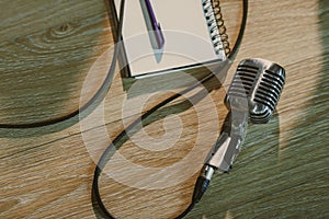 top view of wired vintage microphone lying on wooden table