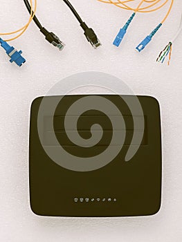 Top view of a wireless router with various patch cords on a white background