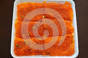 Top view wof Knafeh traditional dessert food on a disposable dish