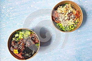 Top view of wok box, bowl of rice on black background. Rice fried and stirred with salmon, avocado, onion, mushrooms, broccoli