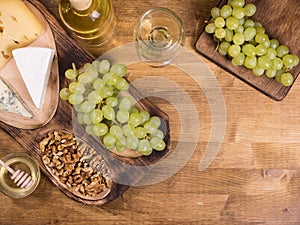 Top view of wolnuts next to fresh grapes on wooden plate in a vintage restaurant