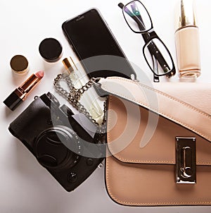 Top view of woman beige bag with accessories smartphone, cosmeti