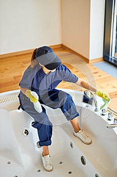 Top view on woman from cleaning service cleaning bath at home
