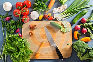 Top view of woman cooking healthy food: cutting vegetable ingredients