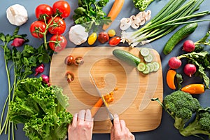 Top view of woman cooking healthy food: cutting vegetable ingredients