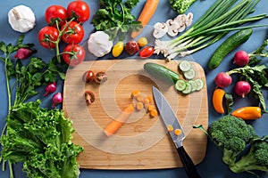 Top view of woman cooking healthy food: cutting vegetable ingredients