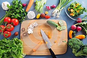 Top view of woman cooking healthy food: cutting vegetable ingredients