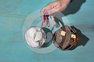 Top view of a woman eating chocolate cookies with vanilla ice cream