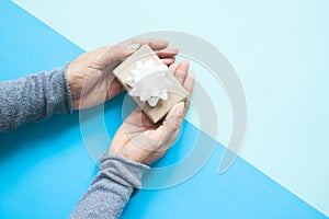 Top view of woman hands holding small gift wrapped craft paper a